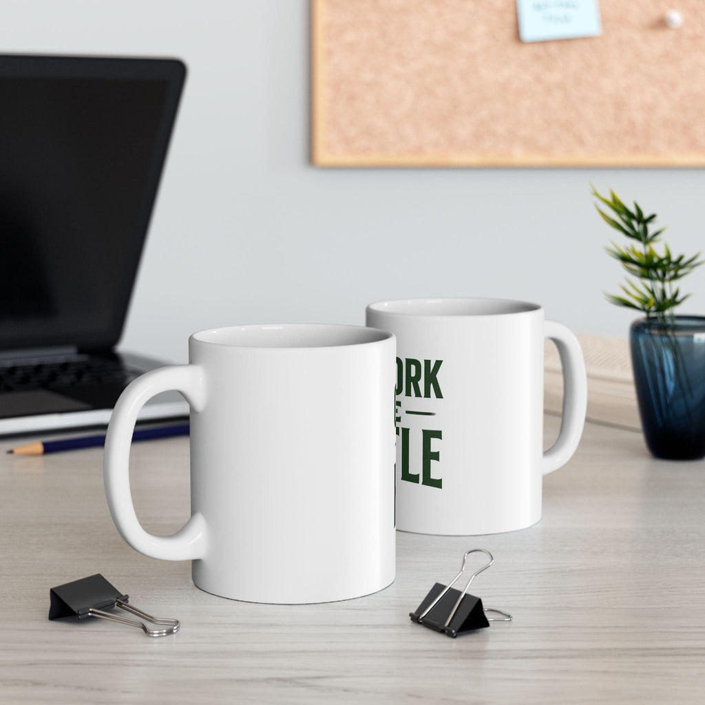 Outwork The Hustle Motivational Mug displayed on a desk with office supplies.